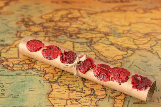 Ancient scroll with seven seals on an old world map. Christian prophecy, apocalypse, judgment day, a revelation of God Jesus Christ, biblical concept. Selective focus.