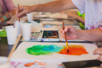 Process of drawing, group class of talented students with painting easels and canvases during lesson of watercolour painting outdoors, drawing class for adult artists in art school