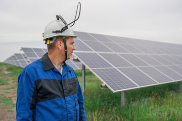 Service Engineer man standing in front of solar panels. Technician maintenance solar cells on Solar Energy Plant under morning sunlight. Technology solar energy renewable