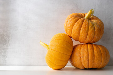 three whole ripe pumpkins on a light background. Autumn harvest