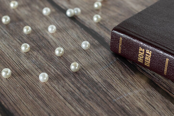 Pearls of great price and holy bible on wooden table. The parable of a hidden treasure of the...