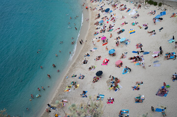Italy, August 2023: beach, Caribbean sea and tourists enjoying their vacation day in Tropea in Calabria. An atmosphere of peace and serenity is perceived