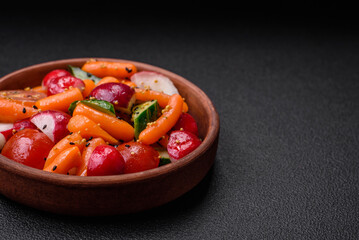 Delicious fresh juicy salad with radishes, tomatoes, carrots, cucumber, spices and herbs