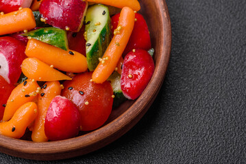 Delicious fresh juicy salad with radishes, tomatoes, carrots, cucumber, spices and herbs