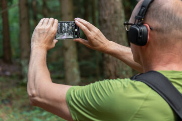 Hands holding phone, taking photo, picture of forest nature - Powered by Adobe