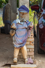 A clothed dummy beside house at the street