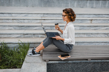 attractive business woman working outside on laptop