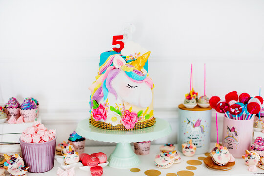 Whimsical and magical birthday cake featuring a sleeping unicorn and vibrant pastel colors.