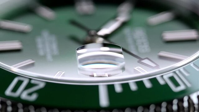 Stylish Luxury Man Wrist Watch With Moving Hand And Multiple Dials. Men's watch in metal with sapphire crystal. Closeup view of rotating watch, running second arrow. green dial. Cyclops watch