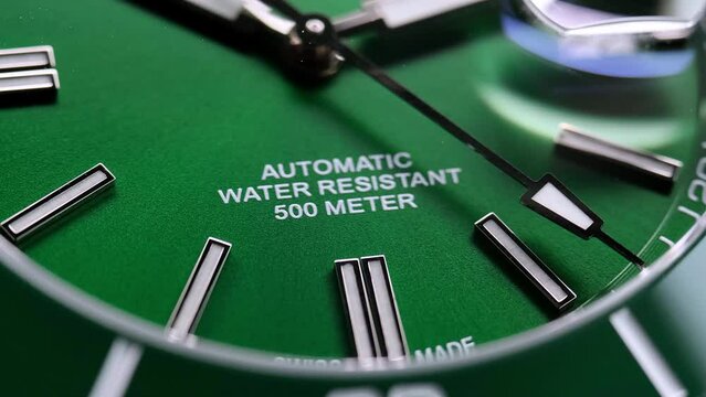 Stylish Luxury Man Wrist Watch With Moving Hand And Multiple Dials. Men's watch in metal with sapphire crystal. Closeup view of rotating watch, running second arrow. green dial. Cyclops watch