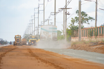 Construction tractor car, bulldozer, or backhoe digging road or street in traffic transportation and agriculture concept. Engine working in urban city town.
