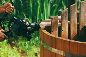 a professional camera in hands. The operator holds a video camera, shoots a video clip. © Igor