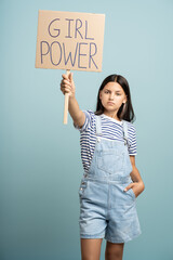 Teenage girl holds banner girl power. Picketing, fighting for women's rights, feminism, getting rid...