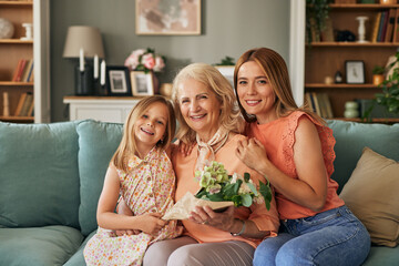 Happy three generation family celebrating grandmothers birthday portrait