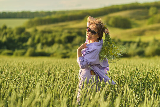 Elderly woman full of vitality, showcasing the benefits of a healthy lifestyle while admiring wildflowers on a beautiful day