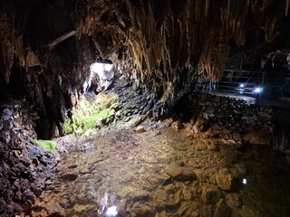 grotta con stalattiti e stalagmiti, attraversata dal fiume