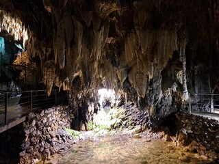 grotta con stalattiti e stalagmiti, attraversata dal fiume