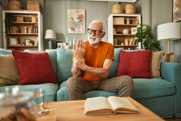 Obraz premium Elderly man suffering from his wrist joint pain at home