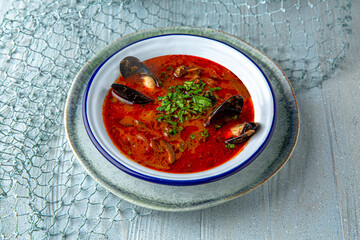 Seafood soup on a blue background. Mediterranean Kitchen. Sea mood menu.