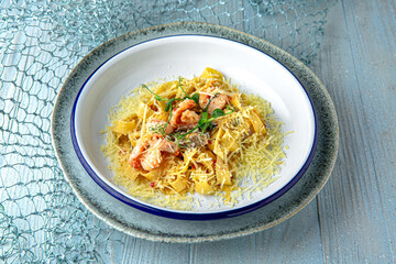 Pasta noodles with seafood on a blue background. Mediterranean Kitchen. Sea mood menu.