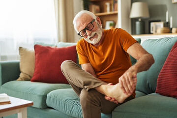 Obraz premium Senior man holding hands on ankle suffering from painful joint ache