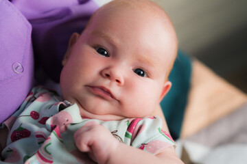 Portrait of a newborn baby girl in her mother's arms.