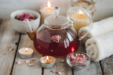 Aromatherapy. Organic natural floral, plant ingredients for spa treatment in salon. Rose petals, essential oil, burning candles, towels, delicious herbal tea, Atmosphere of relax, detention.