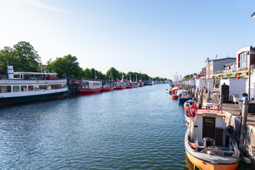 Rostock Warnemuende, Germany. Baltic Sea Warnow river canal with tour boats, fishing, boats, fish restarant boats moored on both sides of the river.
