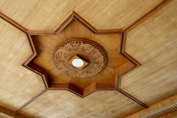 Wooden ceiling with spotlights and chandelier design in the center