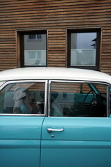 Zweitürige deutsche Limousine der Sechzigerjahre in Zweifarbenlackierung vor einer Fassade aus...