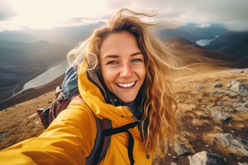 Young woman taking a selfie amidst mountain hiking - obrazy, fototapety, plakaty