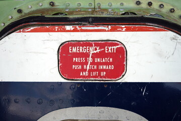Alte Flugzeugtür im Stil der Sechziger Jahre mit Aufschrift Emergency Exit im Sommer auf dem...