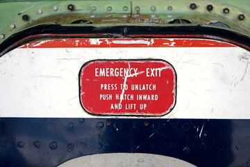 Alte Flugzeugtür im Stil der Sechziger Jahre mit Aufschrift Emergency Exit im Sommer auf dem...