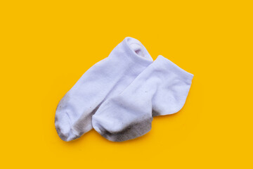 Dirty white socks on yellow background.