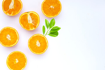 Orange fruit with green leaves on white background.