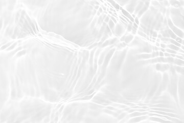 White water with ripples on the surface. Defocus blurred transparent white colored clear calm water surface texture with splashes and bubbles. Water waves with shining pattern texture background.