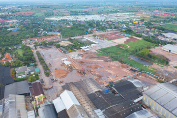Aerial view of stack of different types of large garbage pile, plastic bags, and trash with a tractor car in industrial factory in environmental pollution. Waste disposal in dumping site.