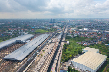 Aerial view of Bangkok Railway terminal station, BTS with skyscraper buildings in urban city, Bangkok downtown skyline, Thailand. Cars on traffic street road on highways.