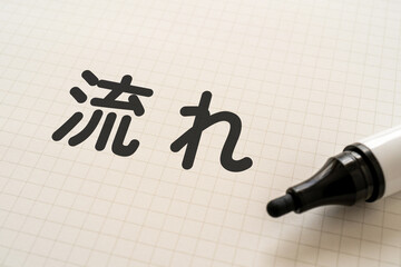 流れと書かれたノートとマーカー