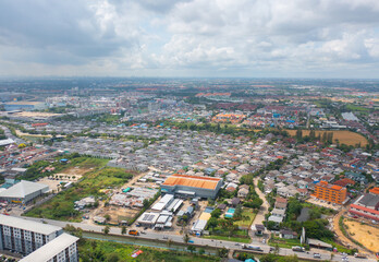 Fototapeta na wymiar Aerial view of residential neighborhood roofs. Urban housing development from above. Top view. Real estate in Bangkok province city, Thailand. Property real estate.