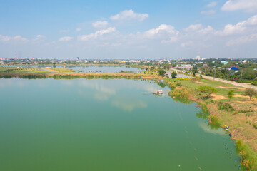 Aerial top view of a garden park with green forest trees, river, pond or lake. Nature landscape background, Thailand.