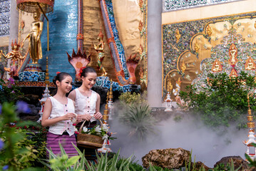 A Thai young girl dressed in traditional costumes visits a Sridonmoon temple in Chiang Mai, Thailand.