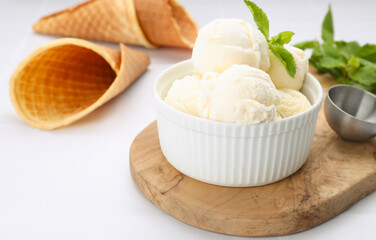 Bowl of ice cream and mint leaves on white table