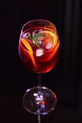 Glass of delicious refreshing sangria on black table