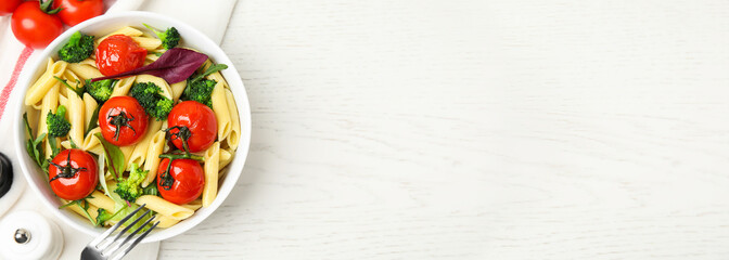 Bowl of delicious pasta with tomatoes, arugula and broccoli on white wooden table, flat lay. Banner design with space for text