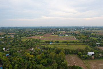 Fototapeta na wymiar Aerial top view of fresh paddy rice, green agricultural fields in countryside or rural area in Asia, Thailand. Nature landscape