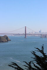 Naklejka premium A breathtaking photo of the Golden Gate Bridge shrouded in iconic San Francisco fog, its majestic red-orange towers piercing through the mist, a symbol of engineering brilliance and coastal beauty