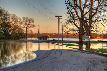 Fototapeta na wymiar Flooded Access. A flooded Mississippi River access just south of downtown Cape Girardeau. The golden tones of the evening light and perfect reflections make for a stunning scene. 