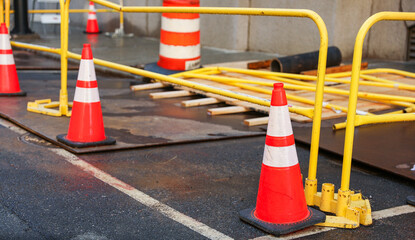 Orange cone on road symbolizes work in progress, caution, temporary disruption, safety measures and...