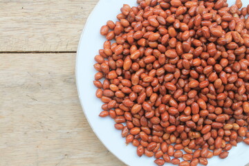 Fried peanuts in a white plate on the table

